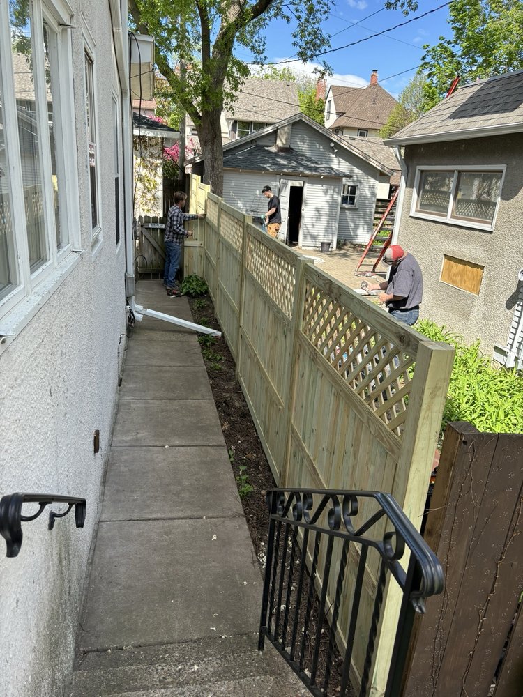 The two owners of A Couple Fence and Repair Guys building a lattice-top privacy fence